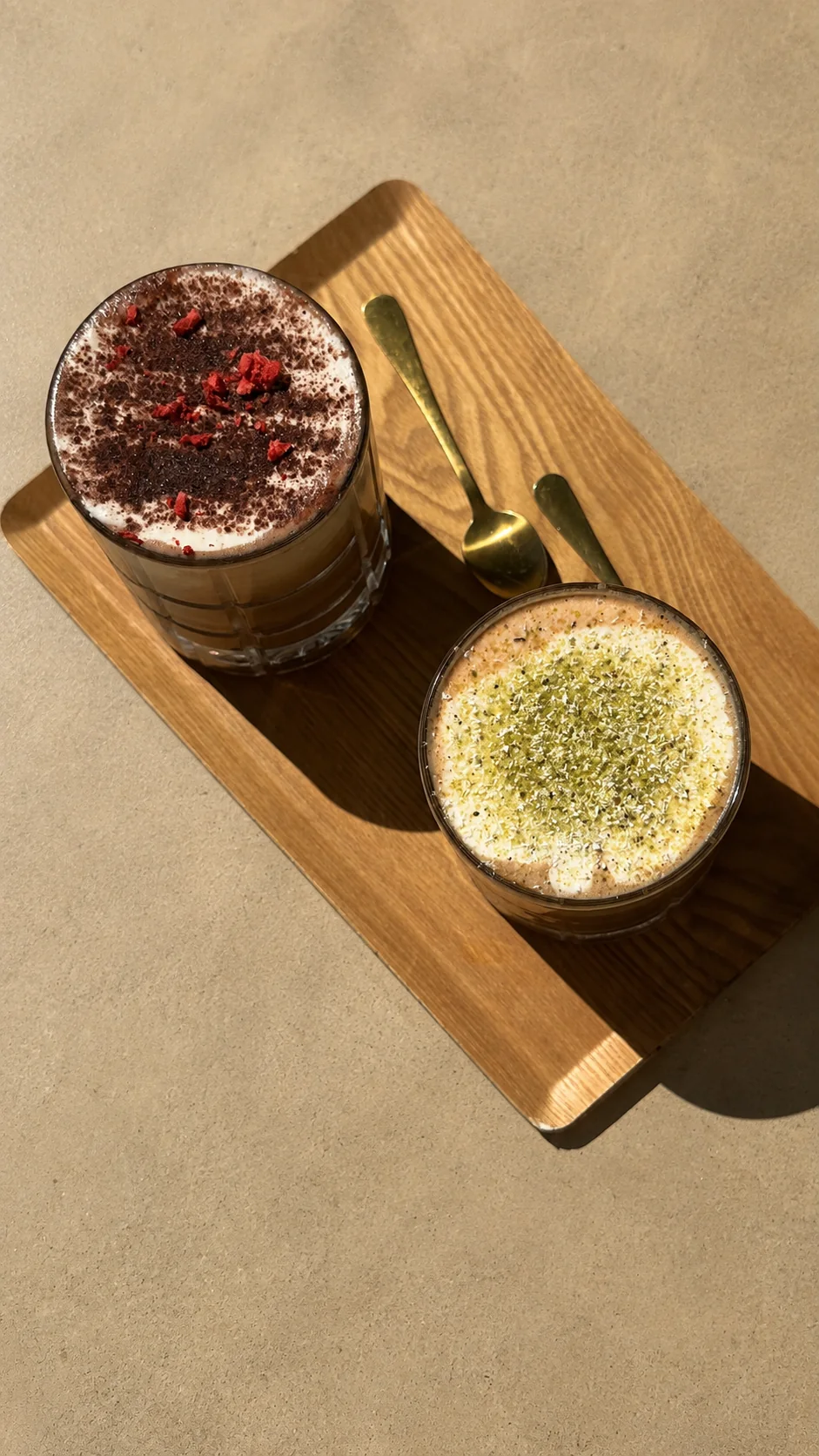 Two café drinks on a wooden tray