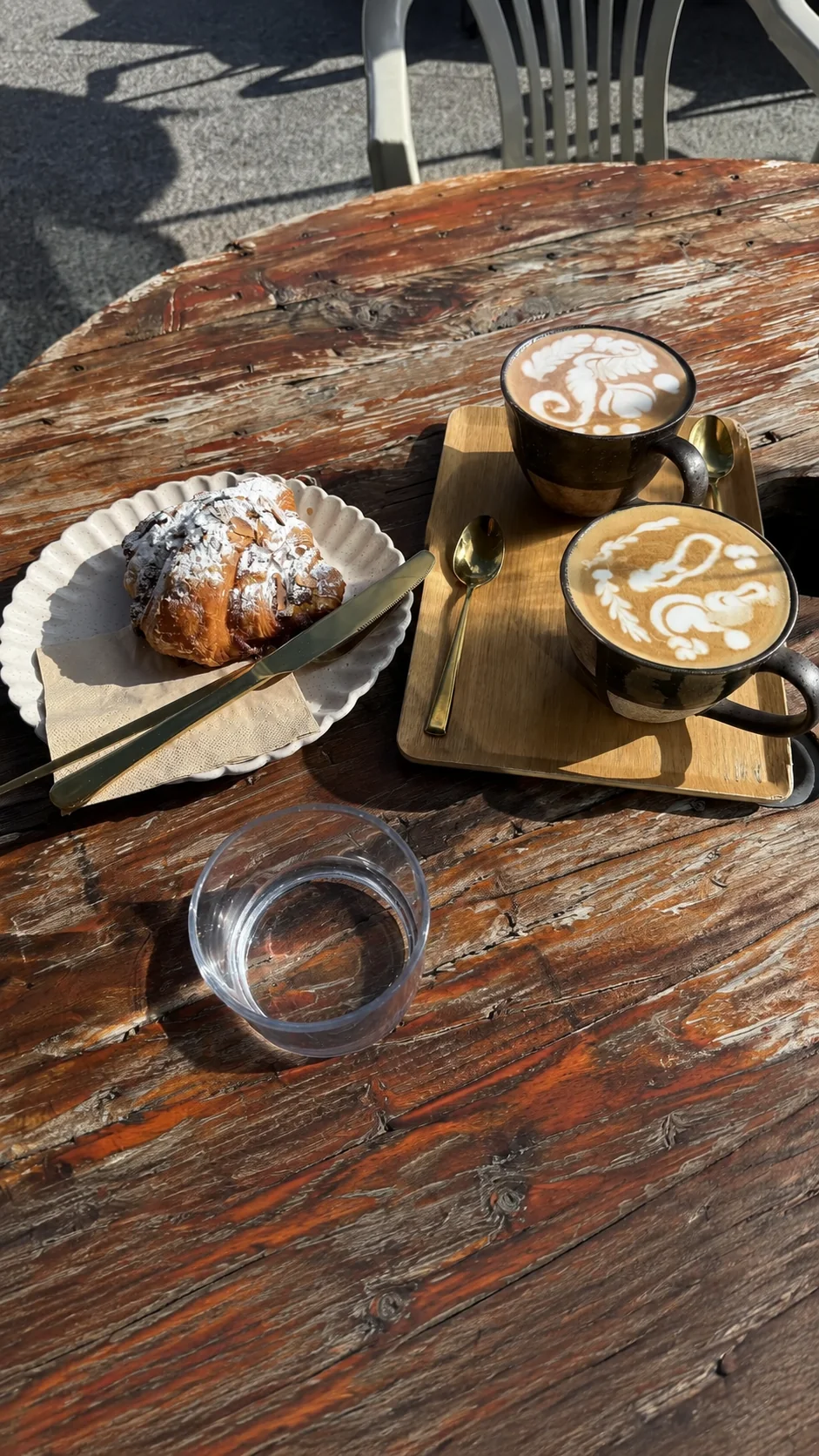 Coffee and a croissant on an outdoor table